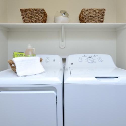 Washer and dryers included a white washing machine with a basket on top